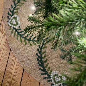Hvid Guirlande juletræstæppe fra Fru Zippe designet af Pelse Asboe syet på hessian med flora spin uldgarn.